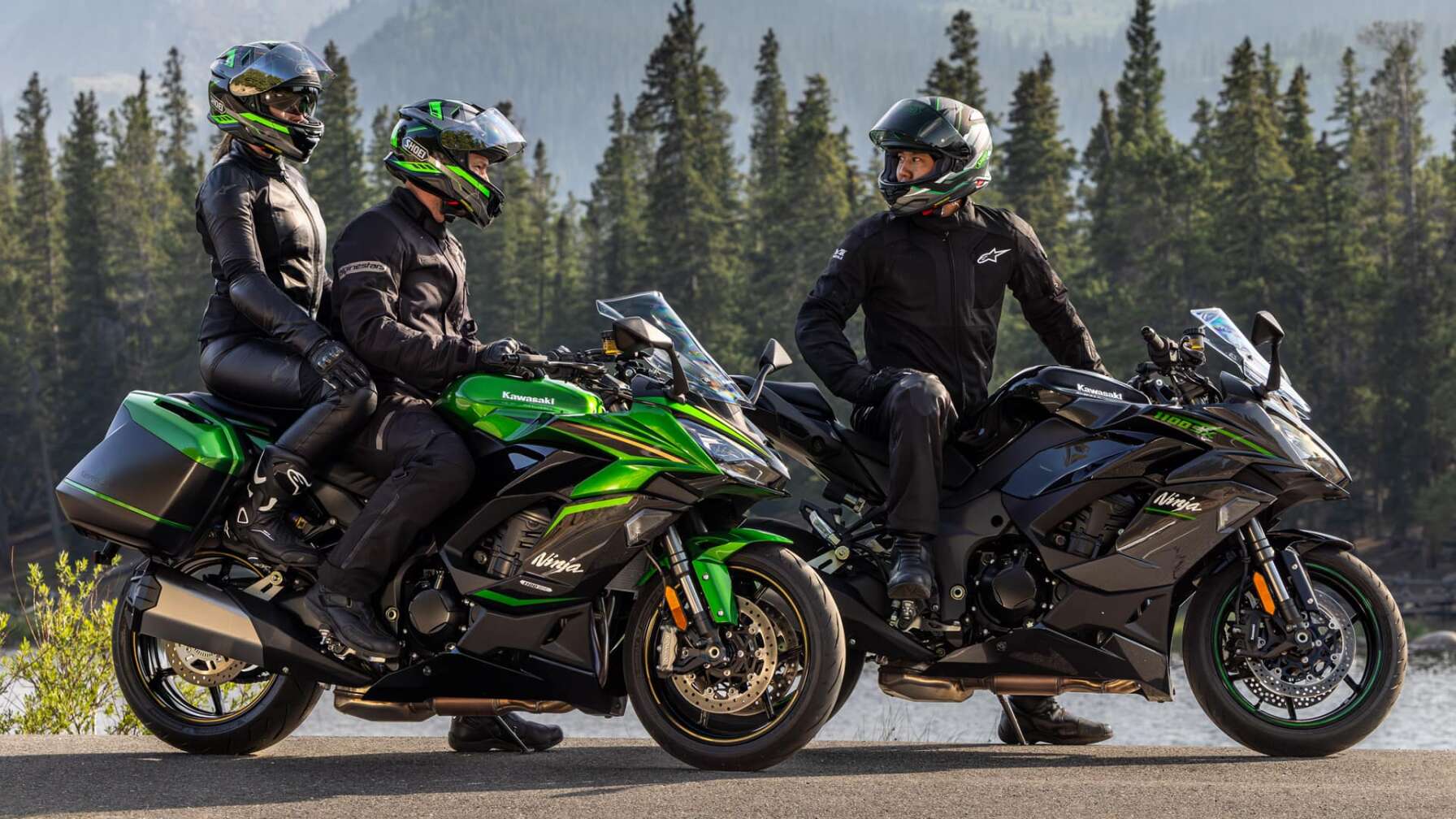 Zwei Kawasaki Ninja 1100SX stehen vor dem Hintergrund eines Waldes, die Fahrer unterhalten sich