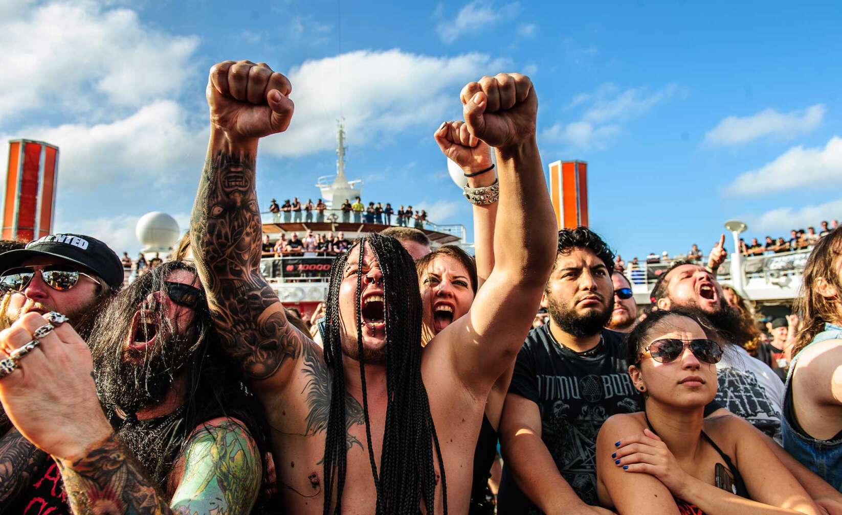 Bilder der 70000 Tons of Metal - Ein Metal-Fan vor der Bühne reißt die Arme nach oben