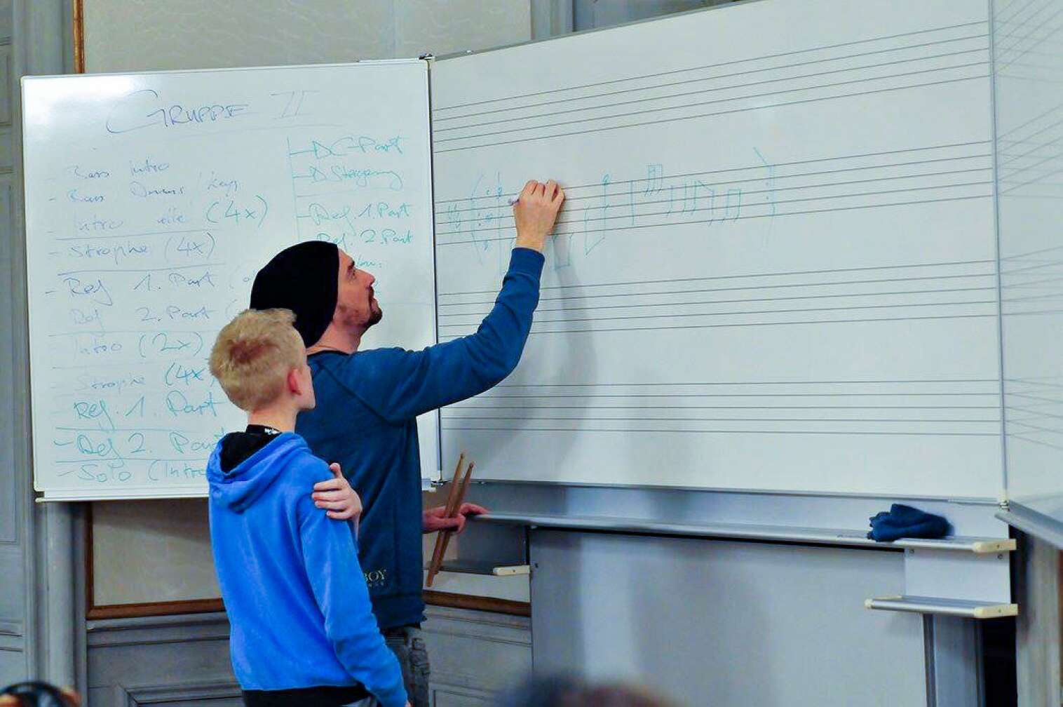 Teilnehmer des Wacken:Music:Camp vor einer Tafel mit Musikunterricht