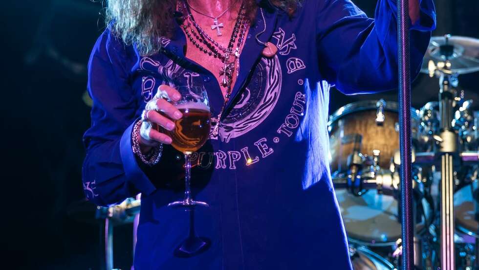 David Coverdale mit Bier in Hand auf der Bühne