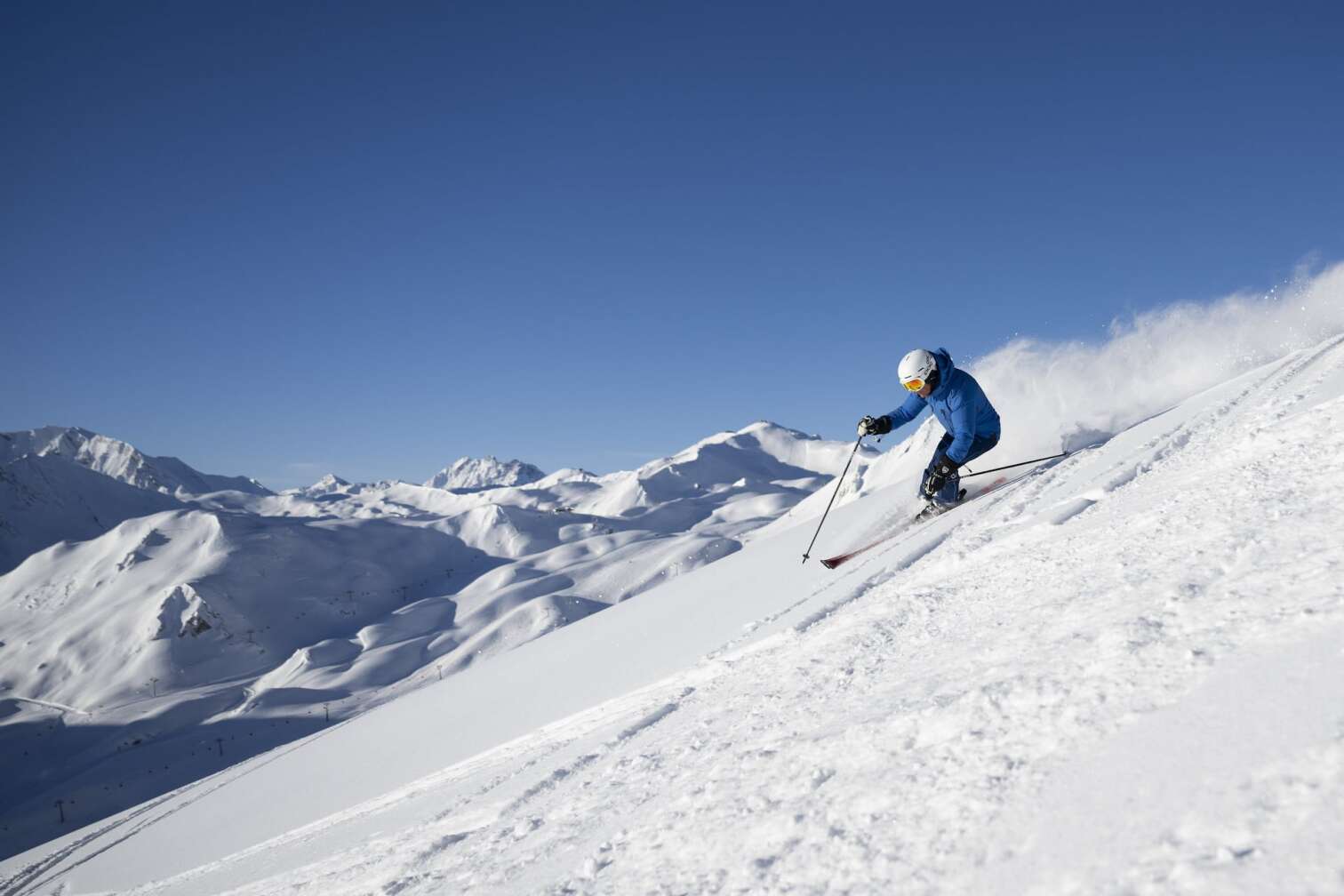 Foto eines Skifahrers vor dem herrlichen Panorama der schneebedeckten Berge in der Silvretta Arena in Samnaun/Ischgl