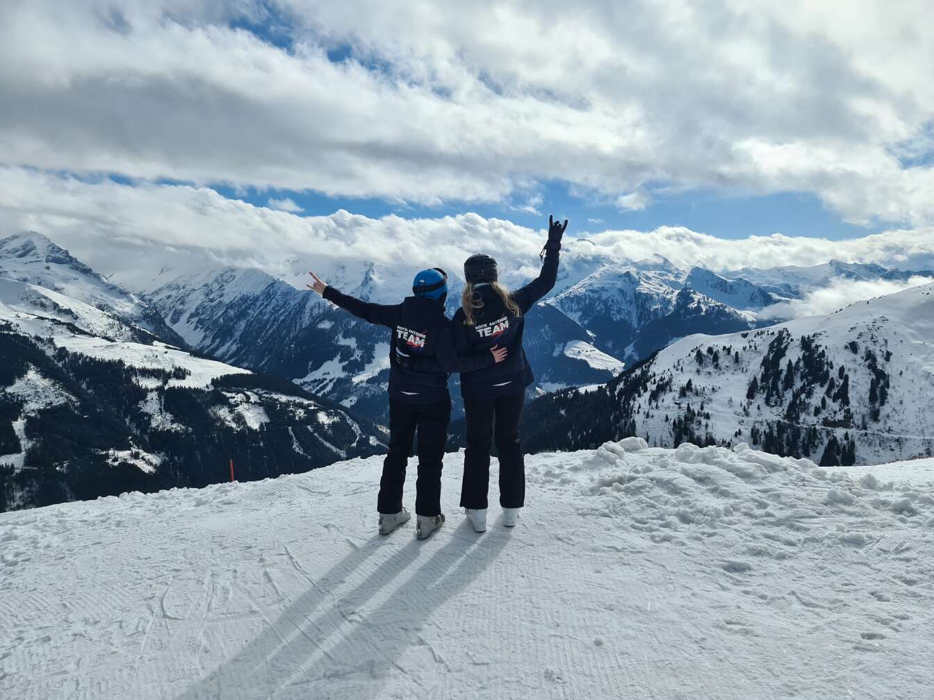 Rock the Mountain Ausflug bei Zauchensee. Zwei Skifahrer mit ROCK ANTENNE Jacke auf dem Berg mit Panorama Aussicht